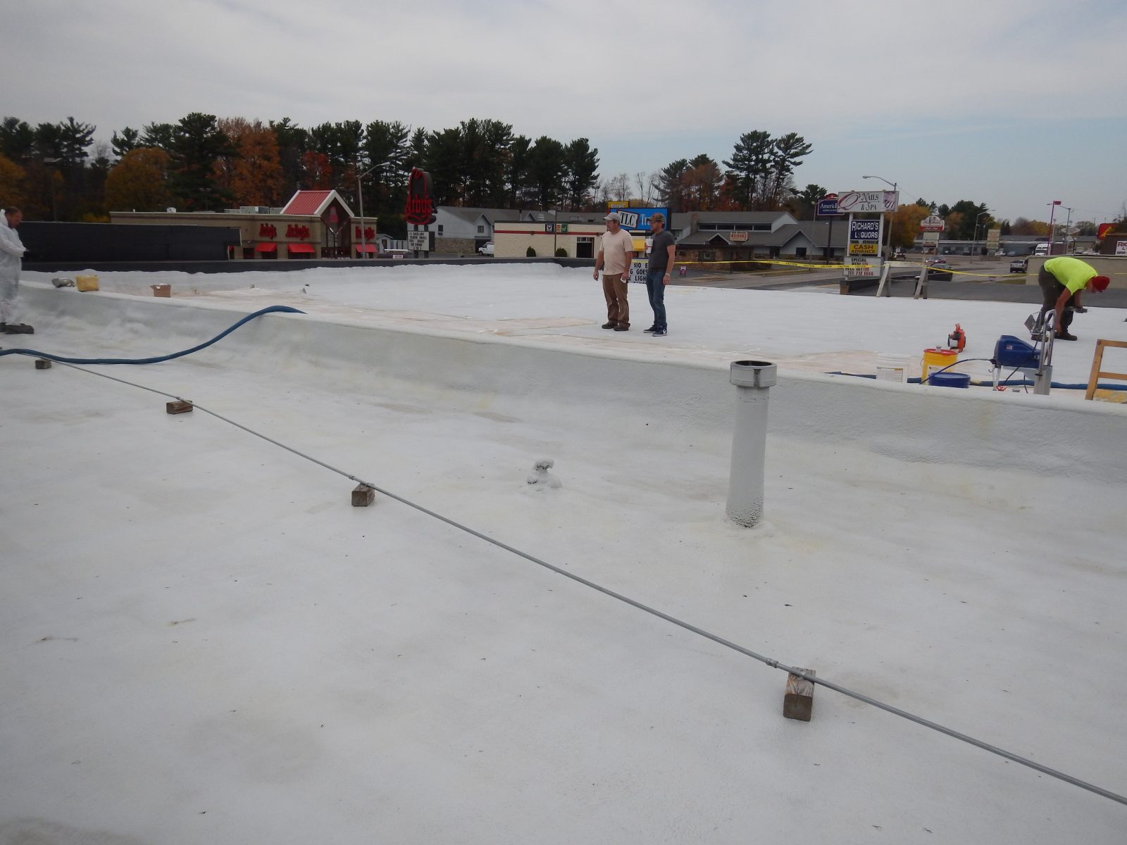 Roof coating application in progress